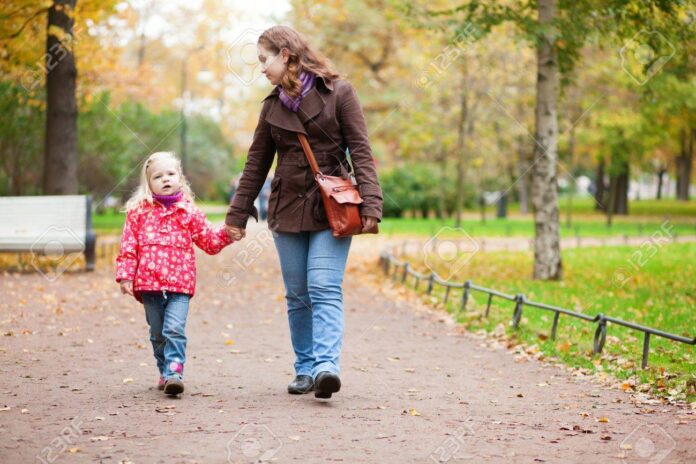 15763160-mother-and-daughter-walking-in-autumn-park-together